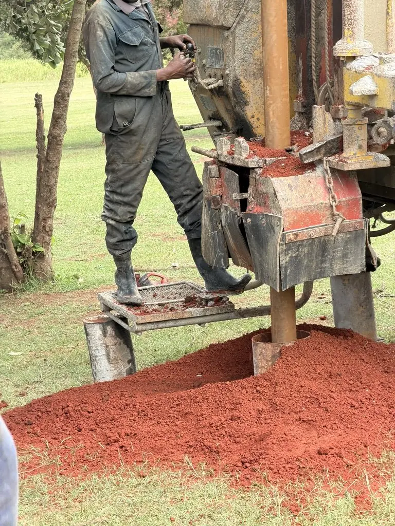 Red soil cuttings rising from the borehole at Bishop Muge Memorial