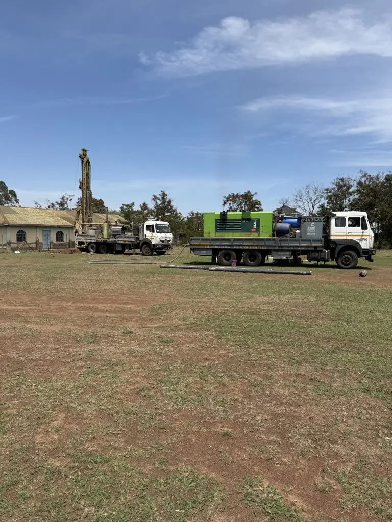 Drilling rig and compressor truck on the field at Urudi, Kisumu County